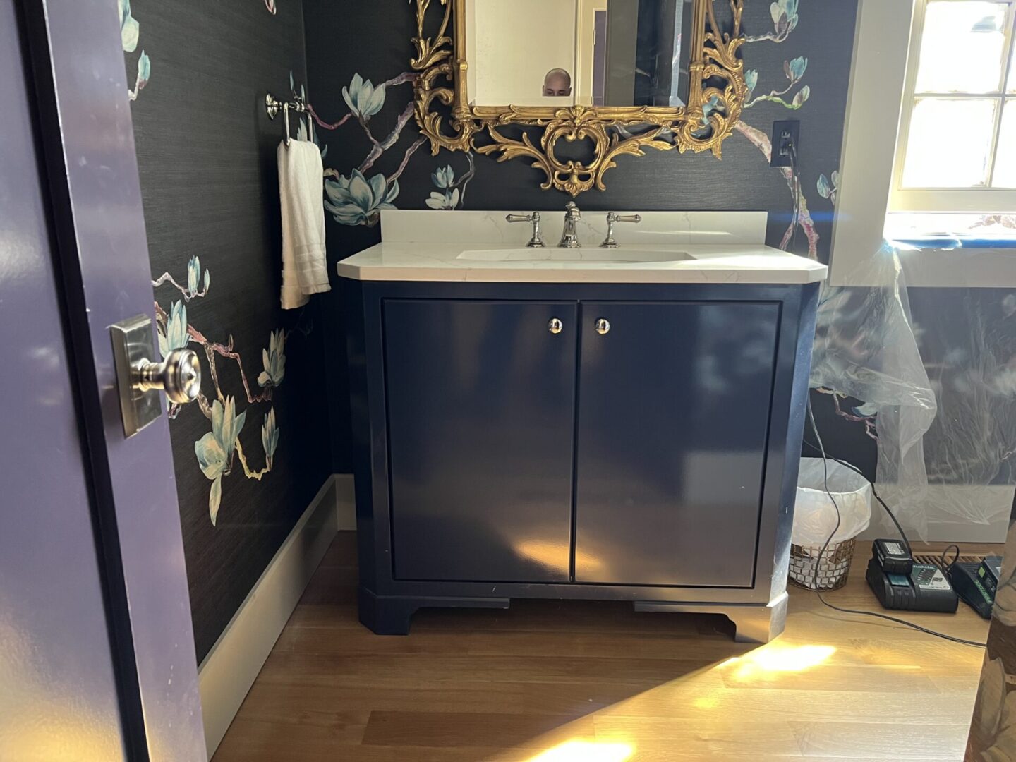 Wash area with mirror and blue cabinets