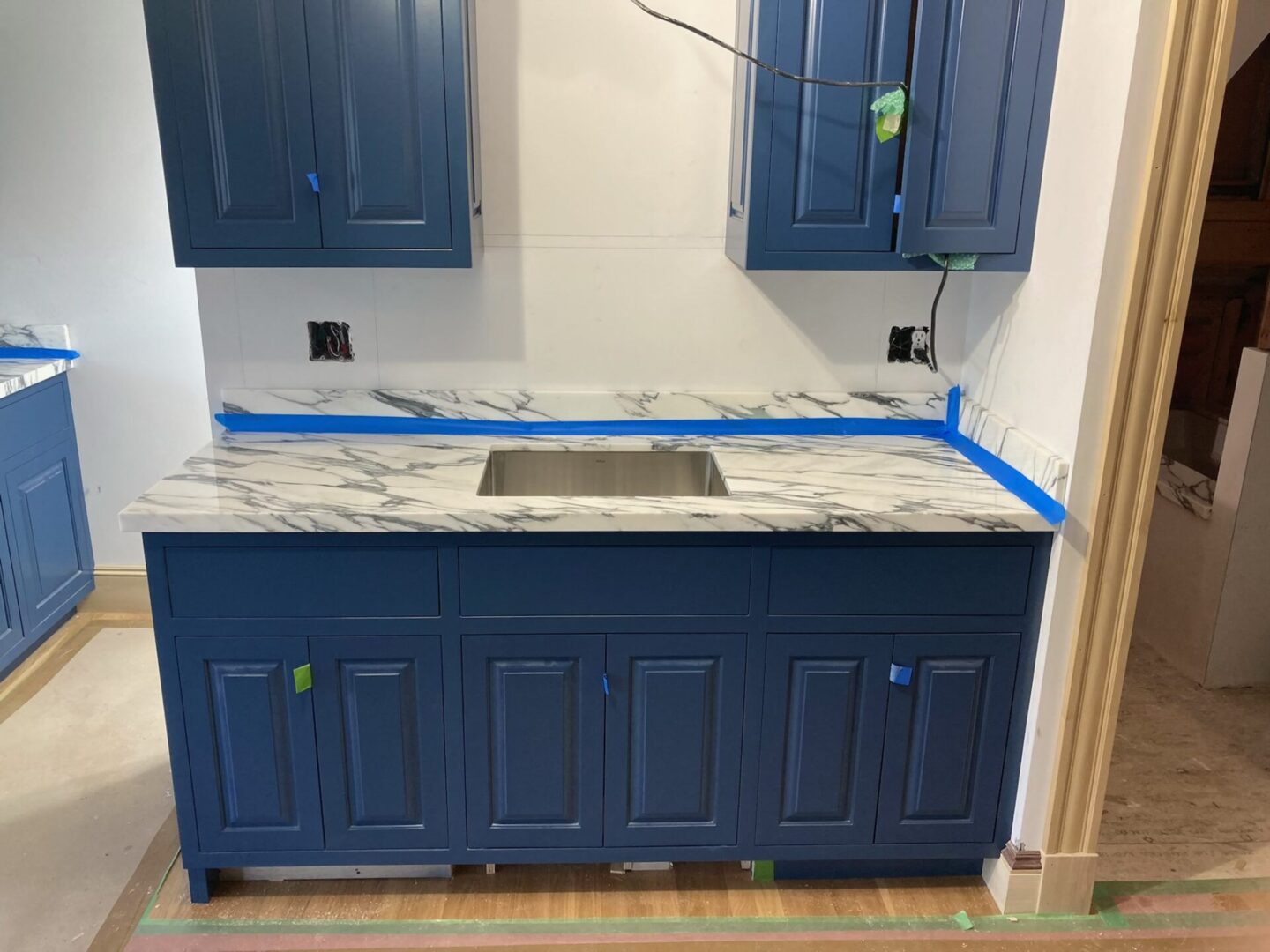 Unfinished view of the wash area with blue cabinet