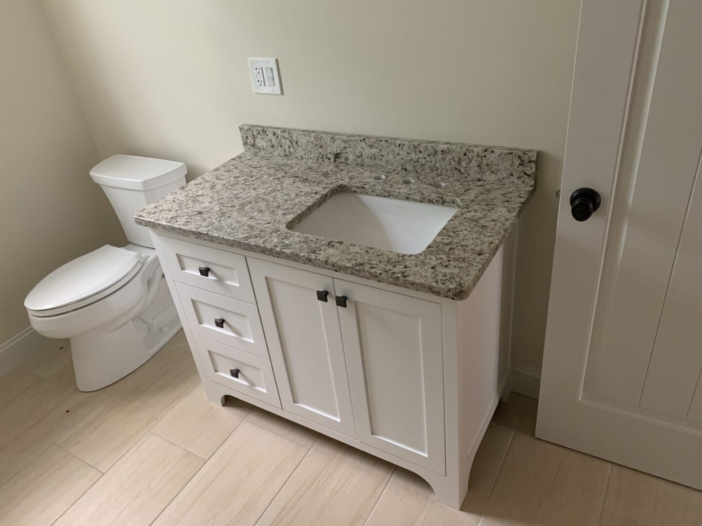 A Sink Cabinet in White With a Gray Granite